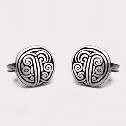 two cufflinks are pictured in front of a white background