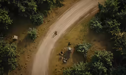 an aerial view of two people riding a bicycle on dirt road