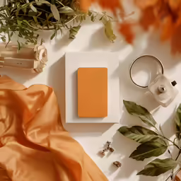 a flower and other decorations sit next to an orange silk