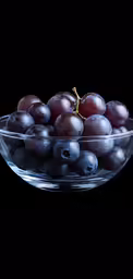 grapes in a clear bowl with black background