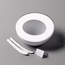 a white, circular object on a dark surface with its components