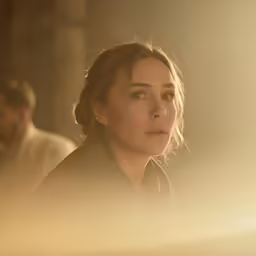 a woman with a braid looking up into the distance