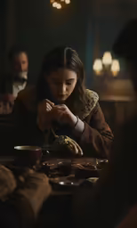 a woman sitting at a table in front of other people