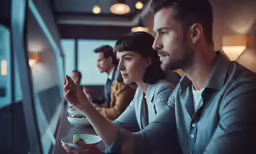two people are eating at a table together