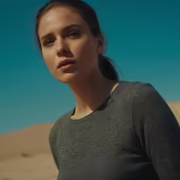 a girl wearing a grey sweater looking over her shoulder