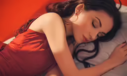 a woman is sleeping in her red dress