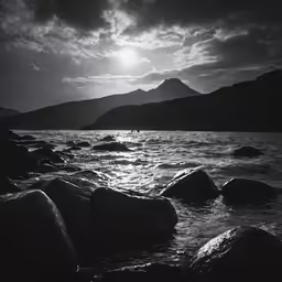 the sun is shining over the rocky shore