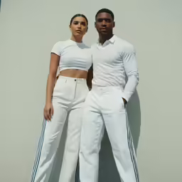 a man and woman in white clothes standing next to each other