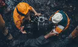 a person with a camera is getting covered in rain