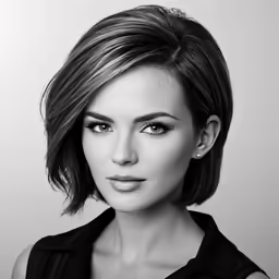 a woman wearing black shirt and eye makeup looking into the distance