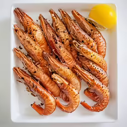 a bunch of grilled shrimp with lemon