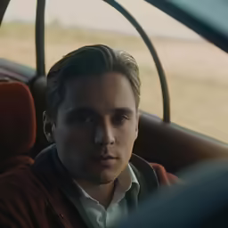 a man in the car looks at the camera
