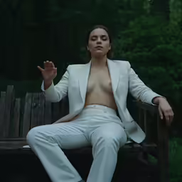 a woman wearing white pants and a blazer