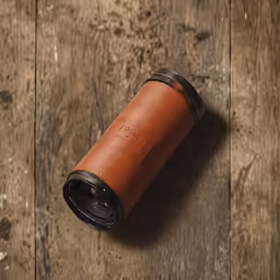 a black and brown canister sits on the ground
