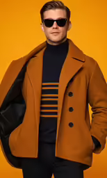 the man is posing wearing a brown pea coat