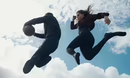 two people flying through the air with their arms outstretched