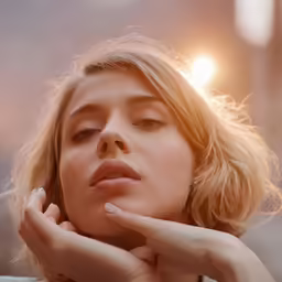 a woman sitting in the sun in her hands