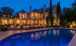 a mansion at night lit up with many lighting