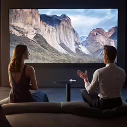 a man and a woman are watching tv in a living room