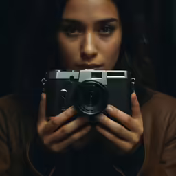 a woman holding up a camera for the camera
