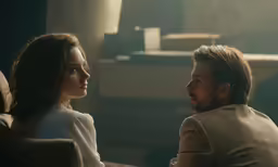 a man sitting next to a woman in front of a mirror