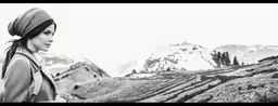 black and white photograph of a woman standing in front of a mountain