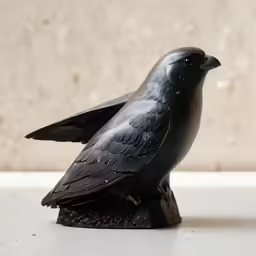a statue of a crow with black feathers