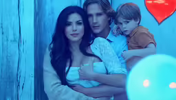 a young man holding a woman and two children
