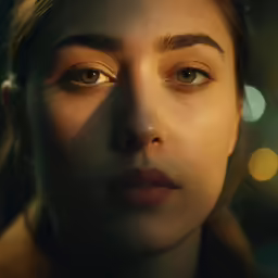 a close up of a woman with lights behind her