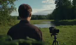 man filming from the back with his camera in front of him