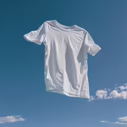 a white shirt on a clothes line under a blue sky