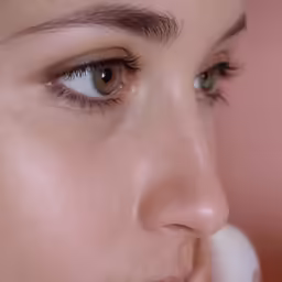 woman with long eyelashes in the image looking off into distance