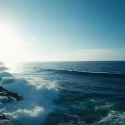 a view from the side of a rocky cliff at the ocean