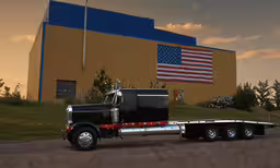 the semi trailer is traveling along the road,a big rig truck with an american flag in the back