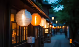 several lamps hanging from the side of houses