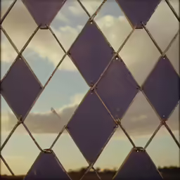 a blue diamond - shaped net has a sky in the background