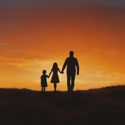 a silhouette image of people walking together with the sun in the background