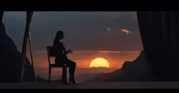 a woman sitting in front of a window at sunset