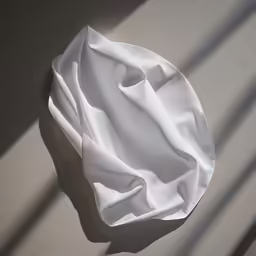 white sheets sit in the sunlight on a gray surface