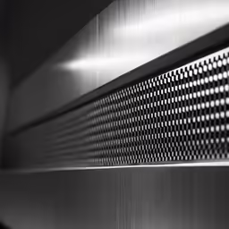 a metallic surface is closeup against the dark background