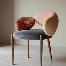 two circular shaped chairs with a pink cushion