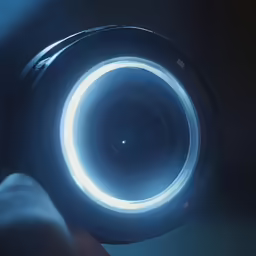 a lens being held in front of a dark room