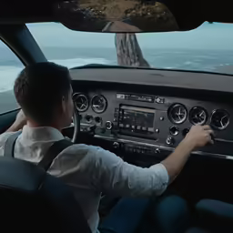 a man driving an airplane on a road next to the ocean