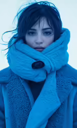 a woman in blue coat with scarf on top