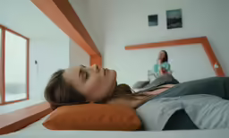 a woman laying on top of a bed with a pillow