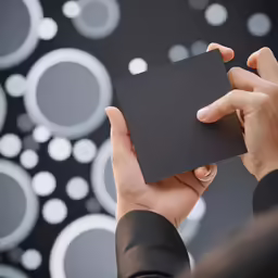 a woman holding up an item from the back of her hand