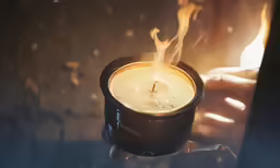 a person holding a candle with fire coming from it