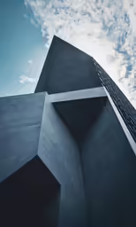 the top of a tall building with the sky and clouds in the background