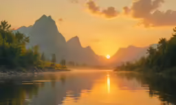 a beautiful sunset on a small river, with mountains rising behind it