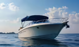 a white boat with a canopy floating in the ocean